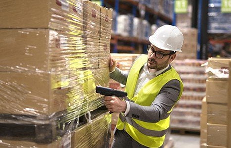 Warehouse operator scanning inventory with rugged handheld terminal